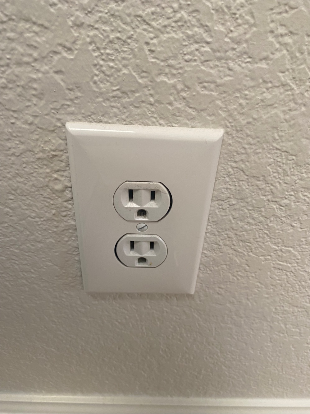 White electrical outlet on textured wall.